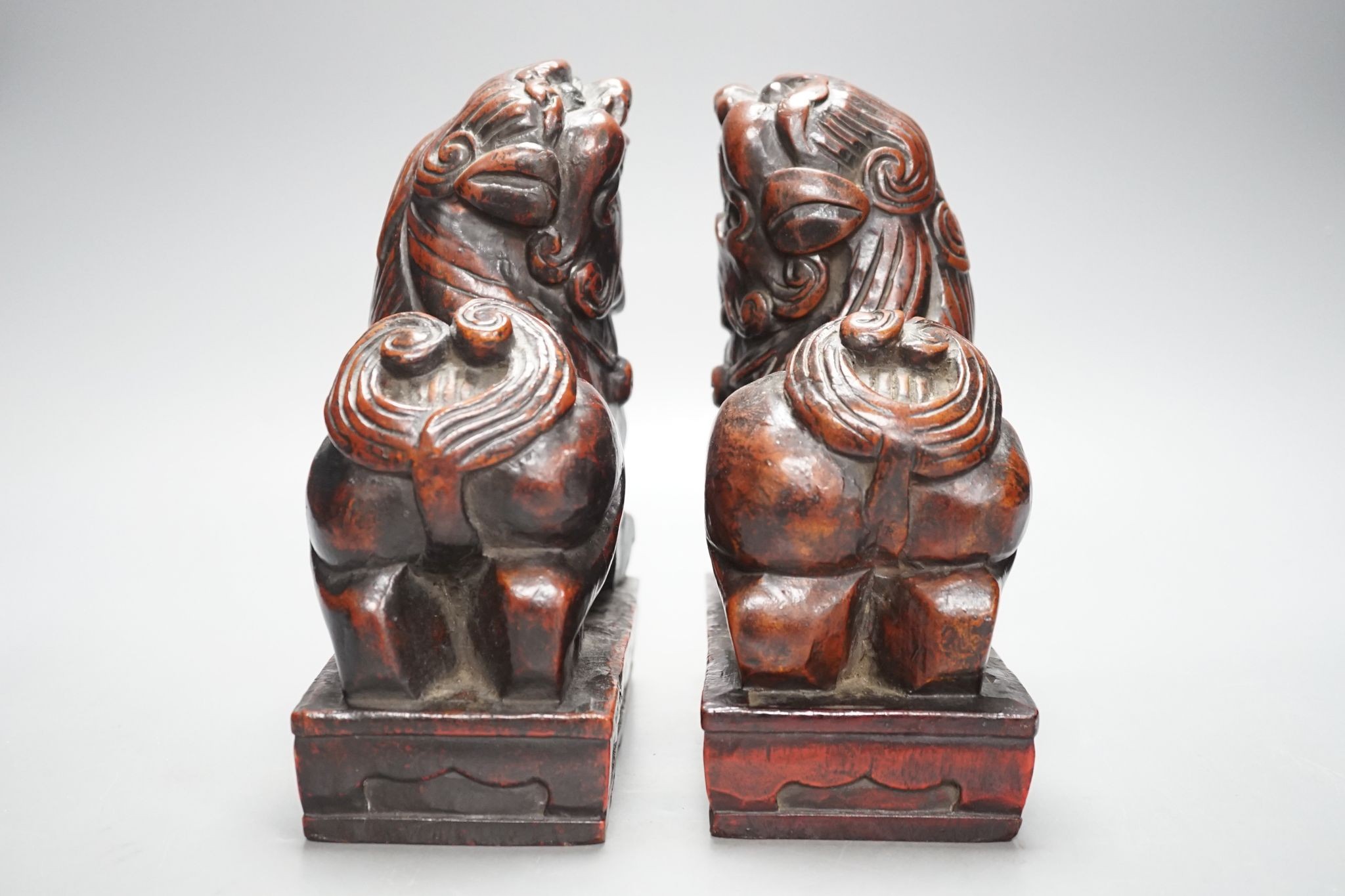 A pair of Japanese carved and red lacquered wood models of temple dogs, Edo period, 21.5 cms high.